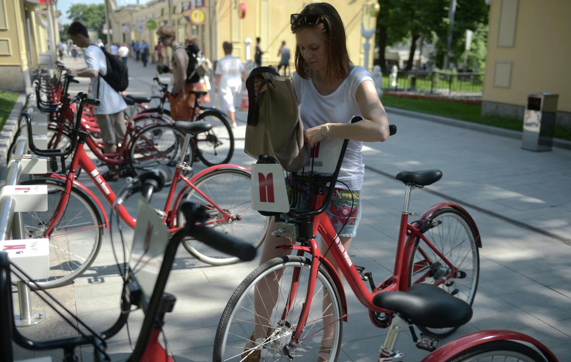 Девушка забирает велосипед со стоянки автоматического велопроката - rnews, 1920, 12.09.2022