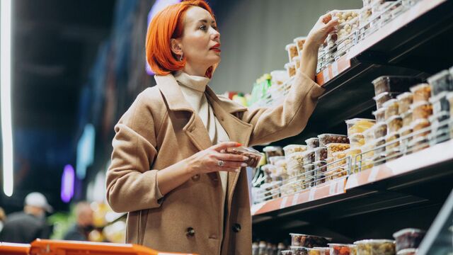 Женщина выбирает продукты в супермаркете