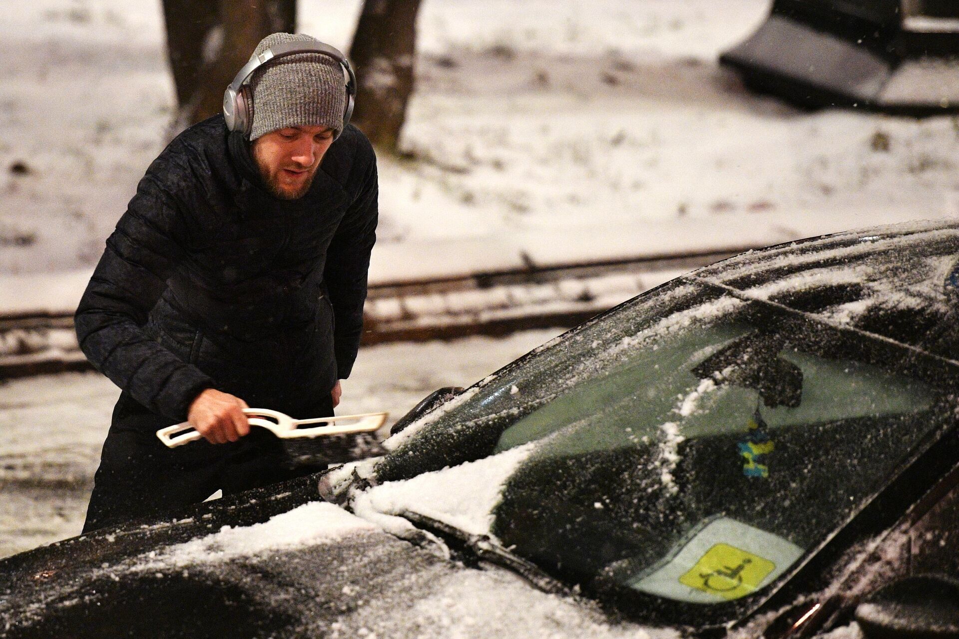 Мужчина очищает от снега свой автомобиль на одной из улиц Москвы - rnews, 1920, 15.12.2022