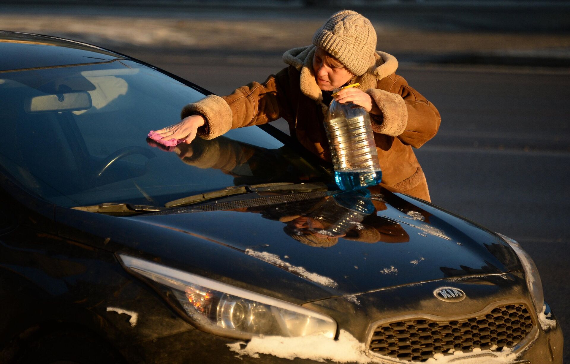 Женщина чистит от инея лобовое стекло машины в морозный день в Москве - rnews, 1920, 16.12.2022