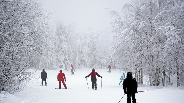 Сноубордисты  и лыжники на северном склоне горы Крестовой горнолыжного курорта Губаха в Пермском крае