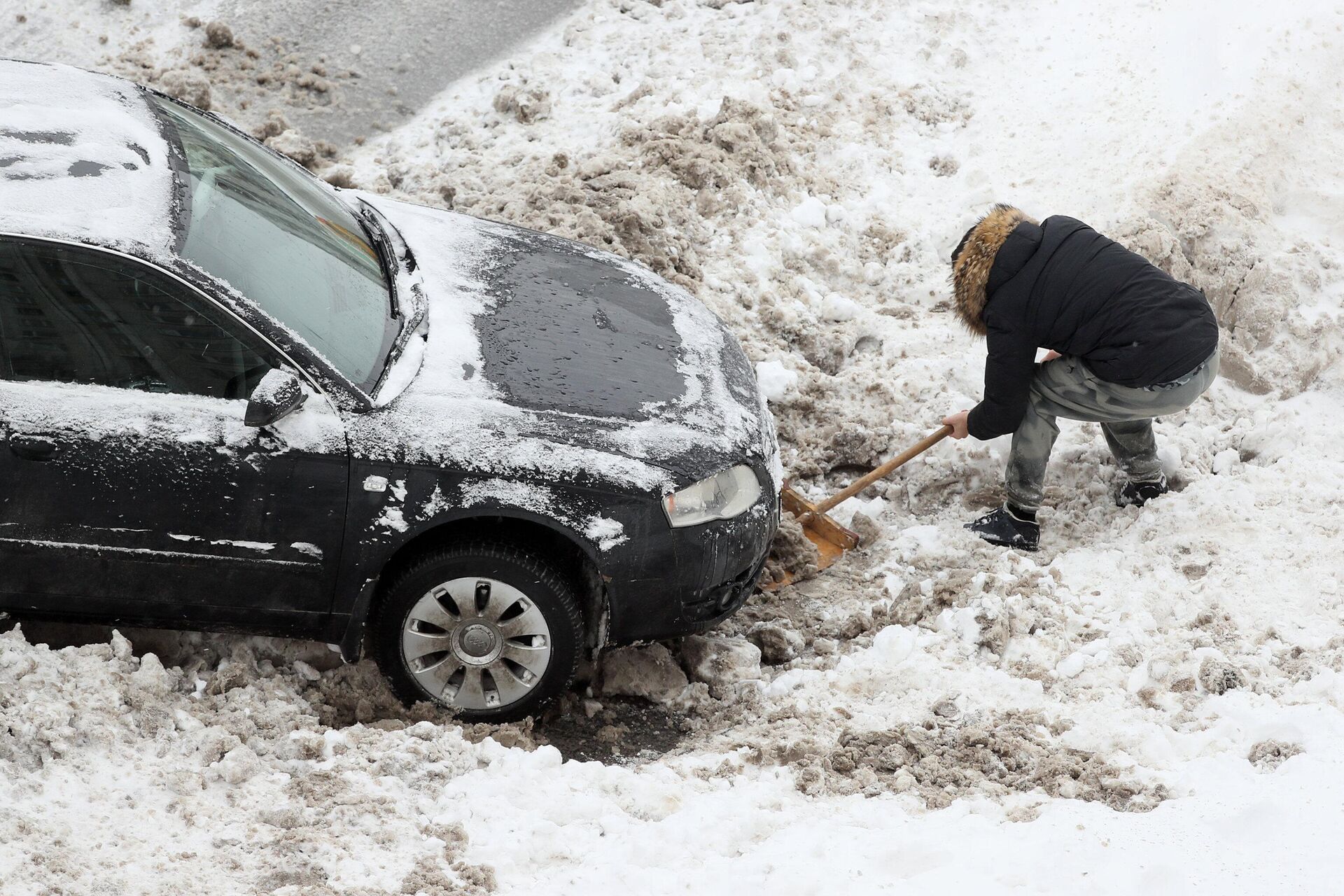 Водитель откапывает из снега свою машину после снегопада - rnews, 1920, 23.12.2022